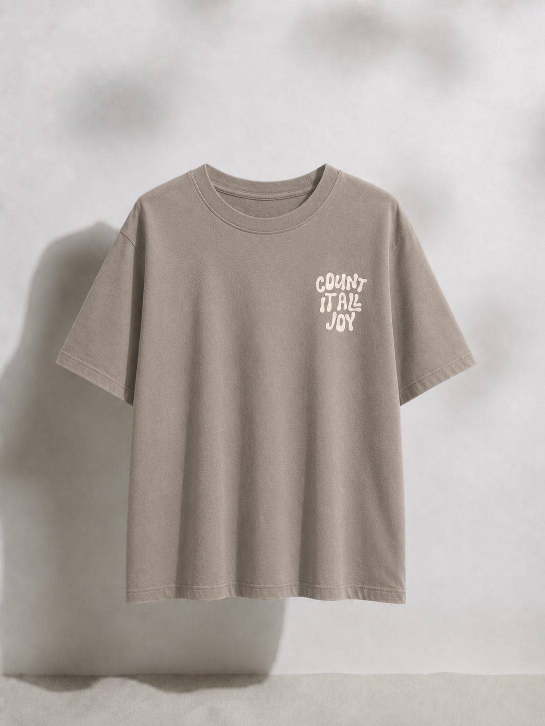 Beige t-shirt with text on a light gray background