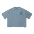 A washed light blue short-sleeve t-shirt with a dark gray graphic print on the left chest, displayed flat against a solid white background.