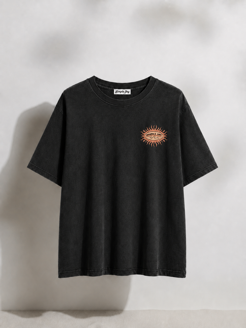 Black t-shirt with a small logo on a light gray background